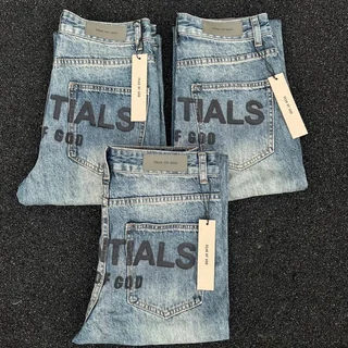 Three pairs of light-wash jeans laid flat with cardboard brand tags still attached