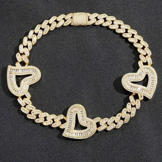 A gold cuban link chain laid in a circle, with heart-shaped stone-set stations