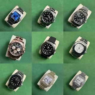 Nine wristwatches with metal and rubber straps, arranged three by three on a green background